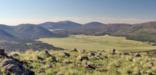 View of an oval, grassy area--the caldera--surrounded by mountains.